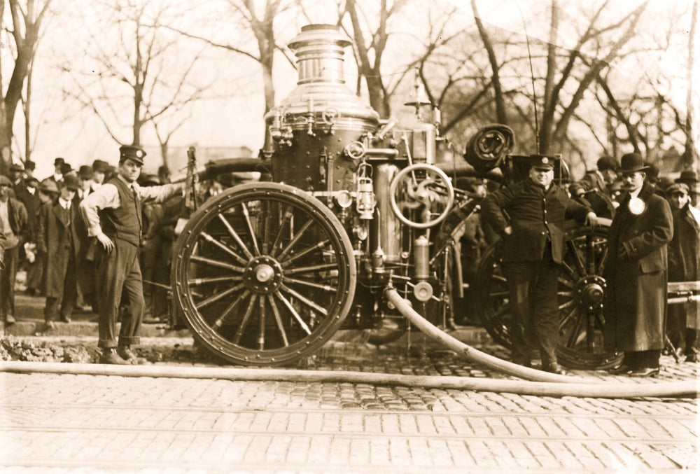 Two firemen standing beside a fire engine poster print
