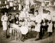 Young Native American men in a metalworking workshop surrounded by metal items.