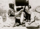 Kneeling Hopi woman combing hair of young girl poster print.
