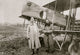 Capt. Berthaut and Capt. Hoppe in front of a German bi-plane poster print.