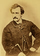 John Wilkes Booth half-length portrait poster print showing him facing left with a cane.
