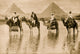 Camel Men & Pyramids in Egypt Reflecting on the Nile Poster Print