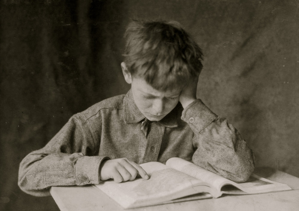 A Boy Reads a Book Poster Print