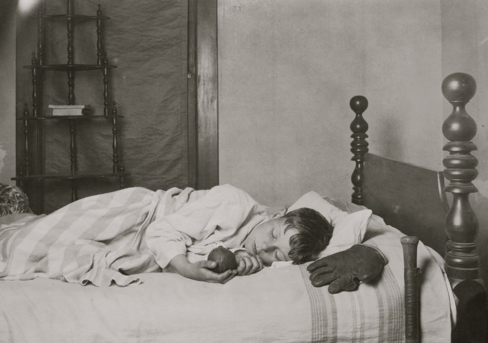 Boy Asleep in His Bed Poster Print featuring a baseball and glove.