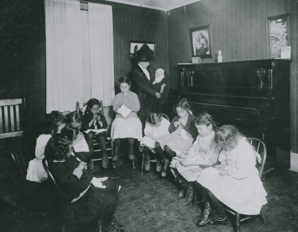 Sewing Class at Sprague House Settlement Poster Print showing a director holding a deserted baby.
