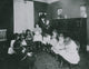 Sewing Class at Sprague House Settlement Poster Print showing a director holding a deserted baby.