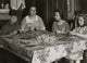 Cottage Industry Poster Print depicting a family stringing material in piecework at home.