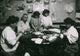 Family Rolling Cigarette Cases Poster Print showing a humorous scene