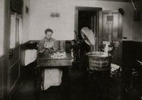 Mrs. Eugene Lampron putting bristles into toothbrushes in her kitchen - Poster Print