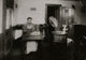 Mrs. Eugene Lampron putting bristles into toothbrushes in her kitchen - Poster Print