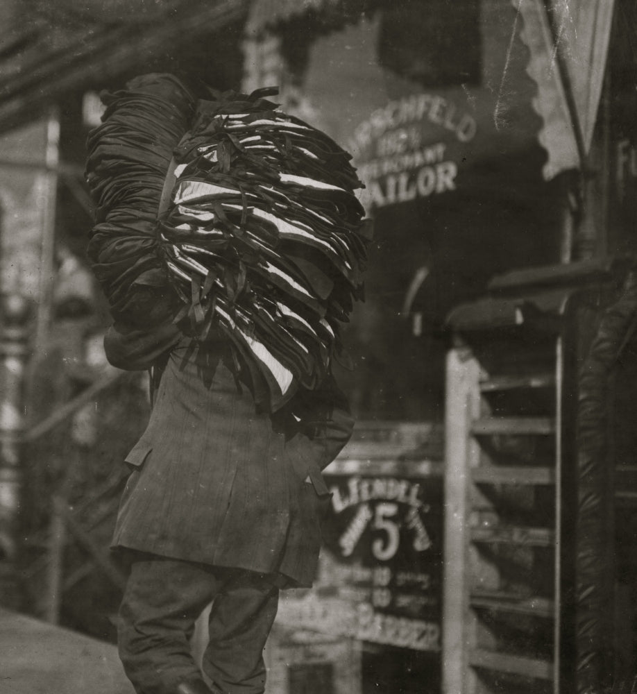 Heavy Load Poster Print capturing a man resting with a bundle of vests.