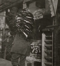 Heavy Load Poster Print capturing a man resting with a bundle of vests.