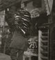 Heavy Load Poster Print capturing a man resting with a bundle of vests.