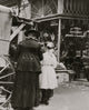 Young vendor sells goods outside a cutlery store poster print.