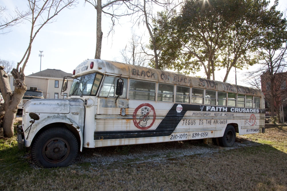 Old bus in Montgomery, Alabama with religious art and words.