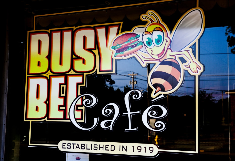 Busy Bee Cafe Poster Print showcasing a lively café scene.