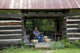 Basket Weaver in Log Cabin Poster Print showcasing traditional craftsmanship