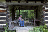 Basket Weaver in Log Cabin Poster Print showcasing a rural artisan.