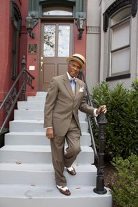 Natty African American Fashionably Dressed Man walking down steps in straw hat and suit poster print