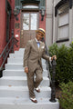 Natty African American Fashionably Dressed Man walking down steps in straw hat and suit poster print