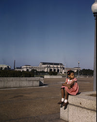 Little girl playing in a park with Union Station in Washington, D.C.