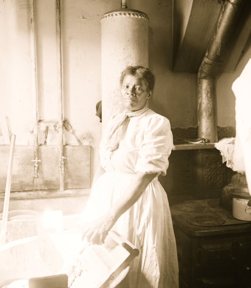 African American woman standing by a washtub with a washboard poster print.