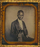 Philip Coker three-quarter length portrait poster print featuring a seated subject with spectacles.