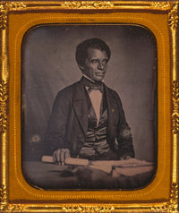 Beverly Page Yates half-length portrait print, seated at table holding paper.