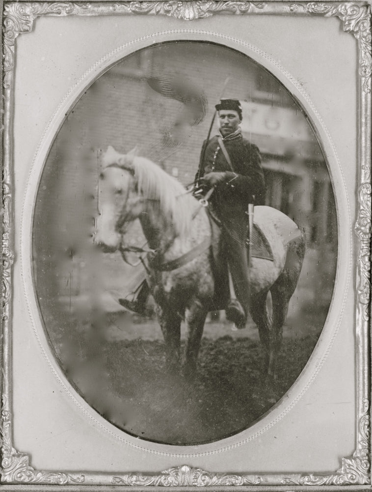 Full-length portrait of an African American soldier on horseback.