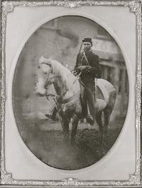 Full-length portrait of an African American soldier on horseback.