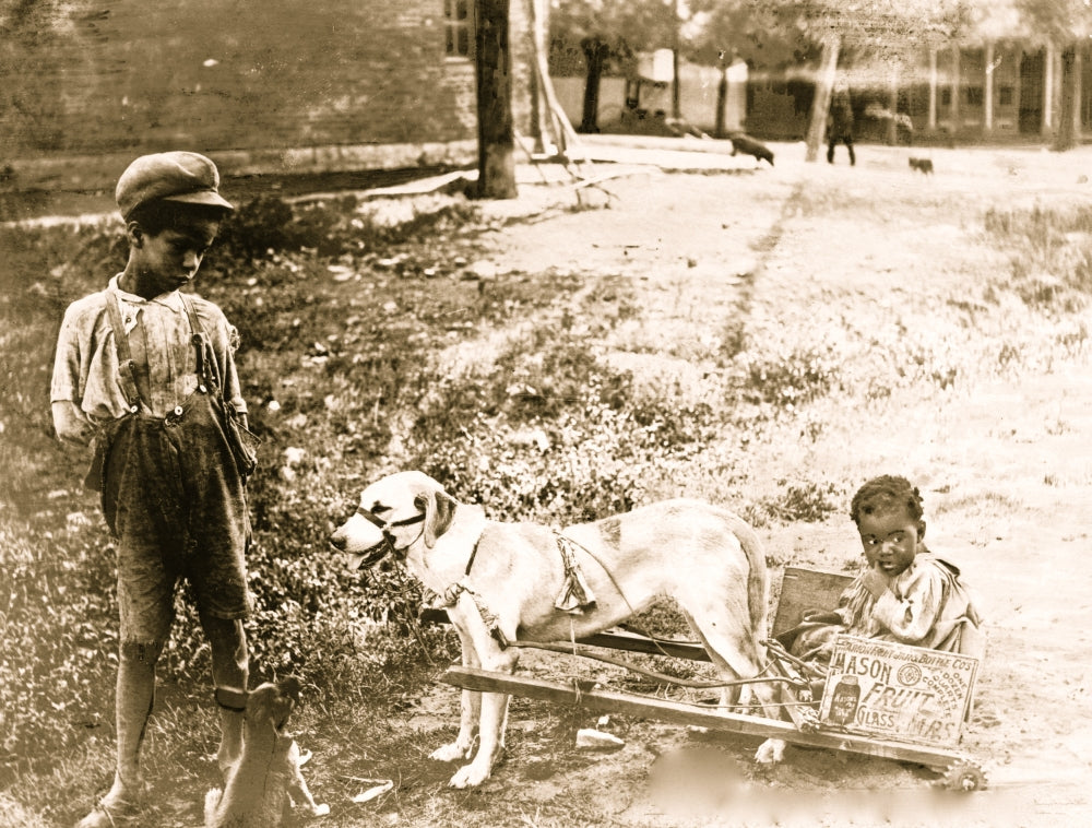 Poster print of two African-American children in a cart pulled by a dog.