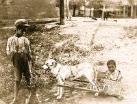 Poster print of two African-American children in a cart pulled by a dog.