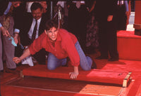 Tom Cruise leaning over his hand and footprints photo print.