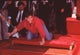 Tom Cruise leaning over his hand and footprints photo print.