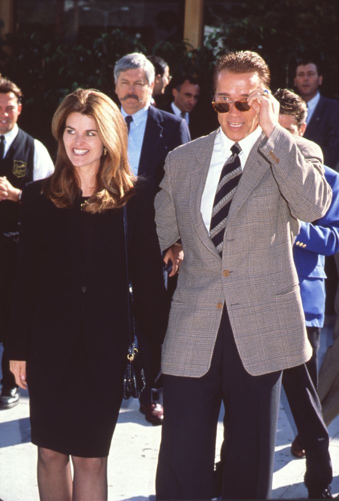 Maria Shriver in black skirt suit with Arnold Schwarzenegger photo print