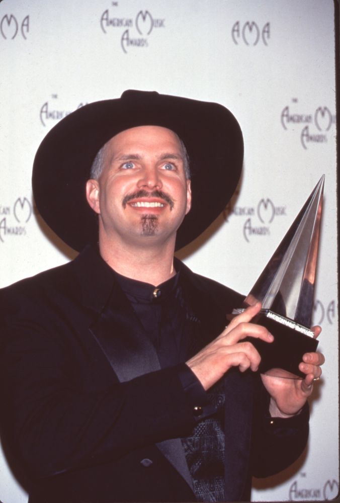 Garth Brooks holding award at 24th American Music Awards photo print.