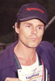 Michael Des Barres pouting holding a sign wearing a Roseanne hat photo print.