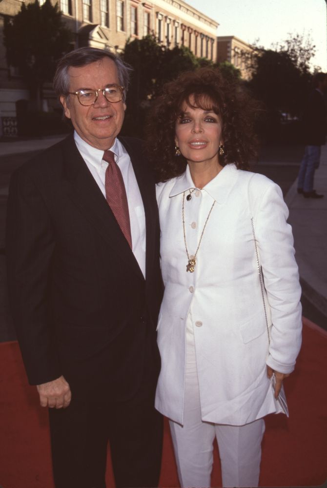 Robert A. Daly in suit with red tie and Carole Bayer Sager in white suit with gold chain photo print.