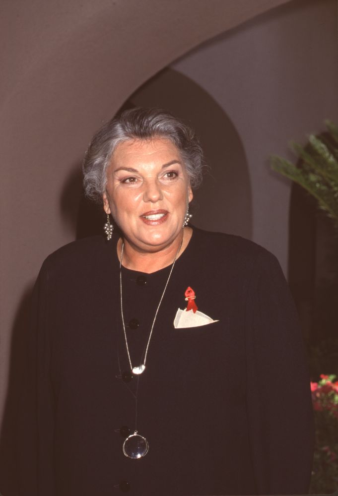 Tyne Daly at CBS TCA Press Tour wearing a silver glass necklace and red ribbon pin