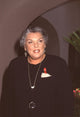 Tyne Daly at CBS TCA Press Tour wearing a silver glass necklace and red ribbon pin