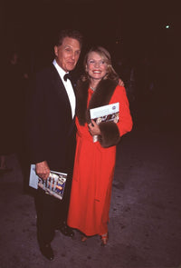 Robert Stack in tuxedo with wife Rosemary in red coat photo print
