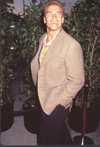 Arnold Schwarzenegger photo print from 'True Lies' premiere with hands in pockets.