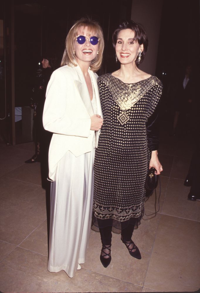 Jensen Buchanan in white outfit and sunglasses with Anna Stuart in gold and black outfit photo print.