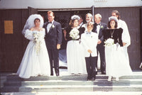 Tom and Roseanne Arnold wedding party photo print featuring joyful celebration on steps.