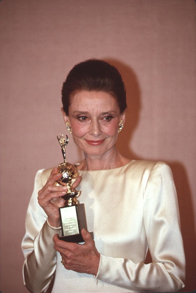 Audrey Hepburn in white gown holding Golden Globe award photo print.