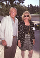 Norman Fell photo print in brown pants and white jacket with wife in black and white patterned outfit.