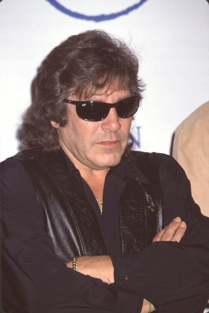 Jose Feliciano photo print in black leather vest with arms crossed.