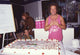 Richard Simmons photo print over cake in pink tank top.