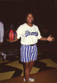 Queen Latifah holding a basketball, wearing blue striped shorts and a Brooklyn shirt.