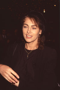Joanna Pacula in all black with a black hat and gold necklace photo print